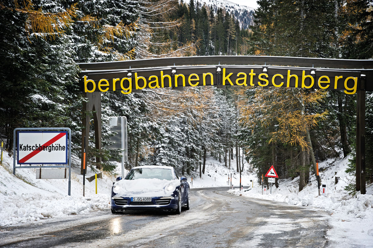 Porsche 911 Carrera 4S driving on snow covered Alpine roads