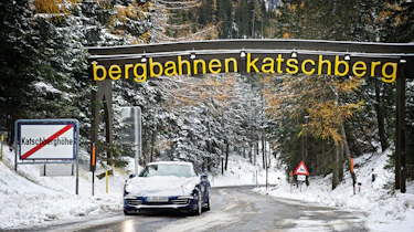 Porsche 911 Carrera 4S driving on snow covered Alpine roads