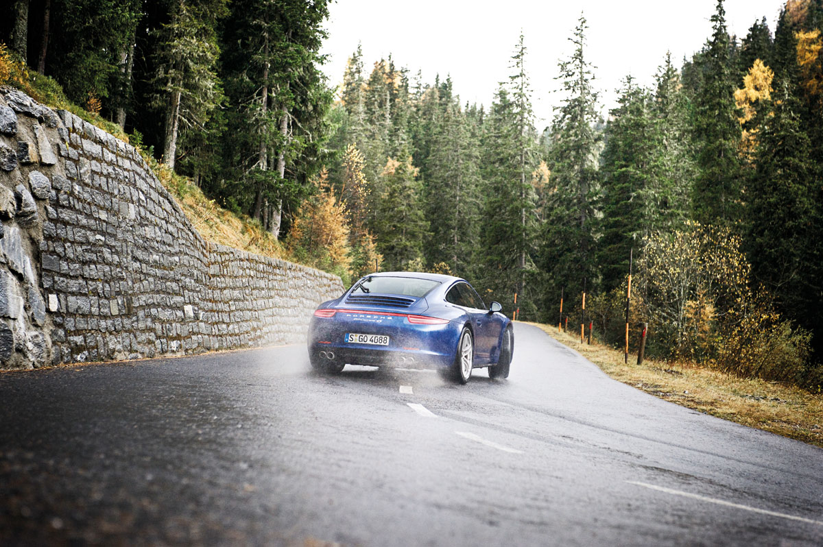 Porsche 911 Carrera 4S drifting on wet hairpin bend