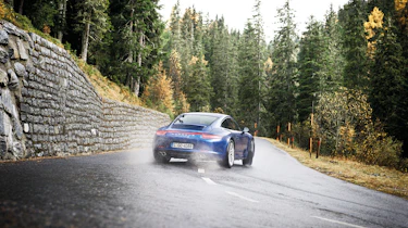 Porsche 911 Carrera 4S drifting on wet hairpin bend