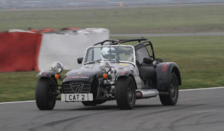 evo sprints a Caterham at Silverstone